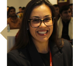Fotografia de perfil de Yane Moriggi a sorrir em ambiente corporativo.